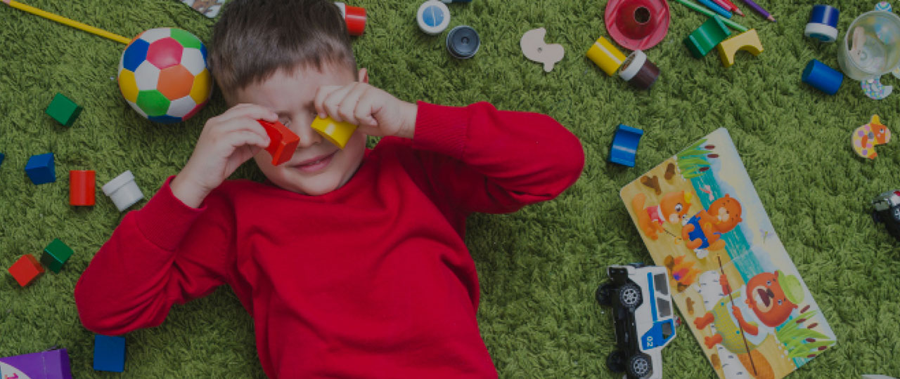 Child covering eyes with blocks